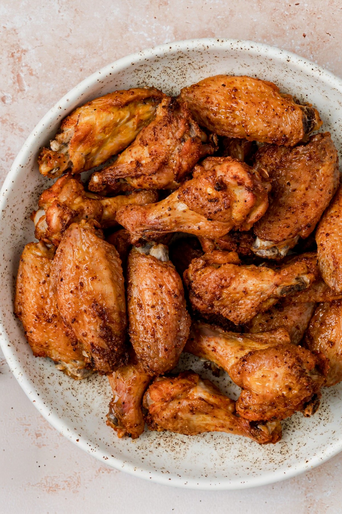 Baked wings in bowl before sauce is added.