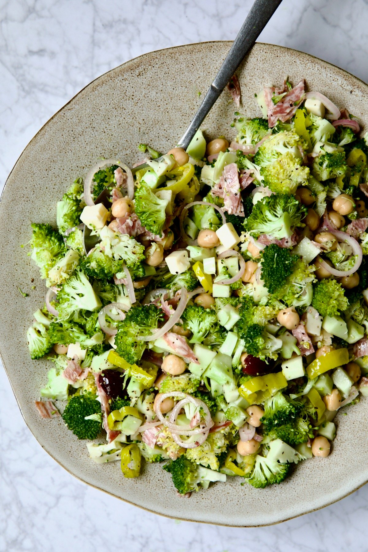 Italian Broccoli Salad in earthenware bowl with serving fork.