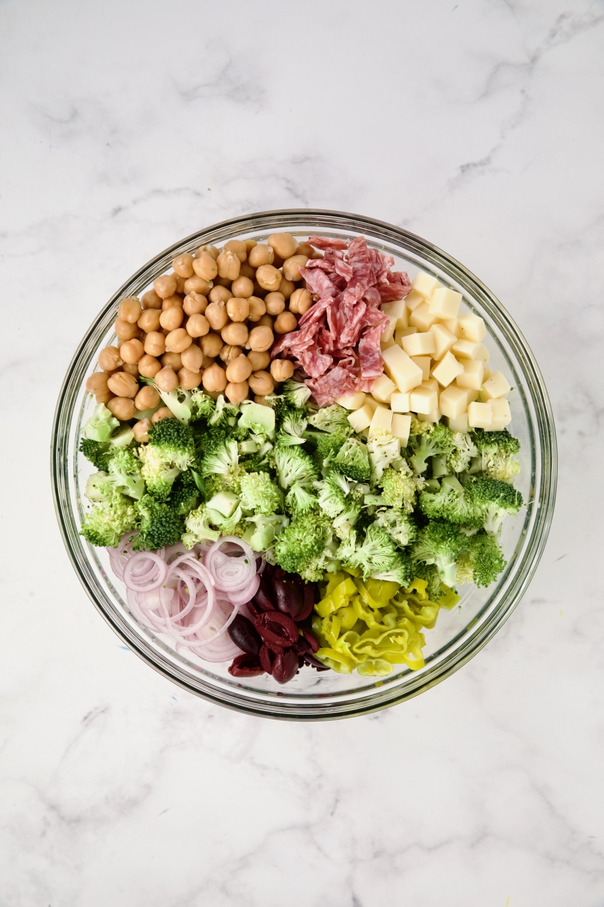 Ingredients for Italian Broccoli Salad in glass bowl before being combined.