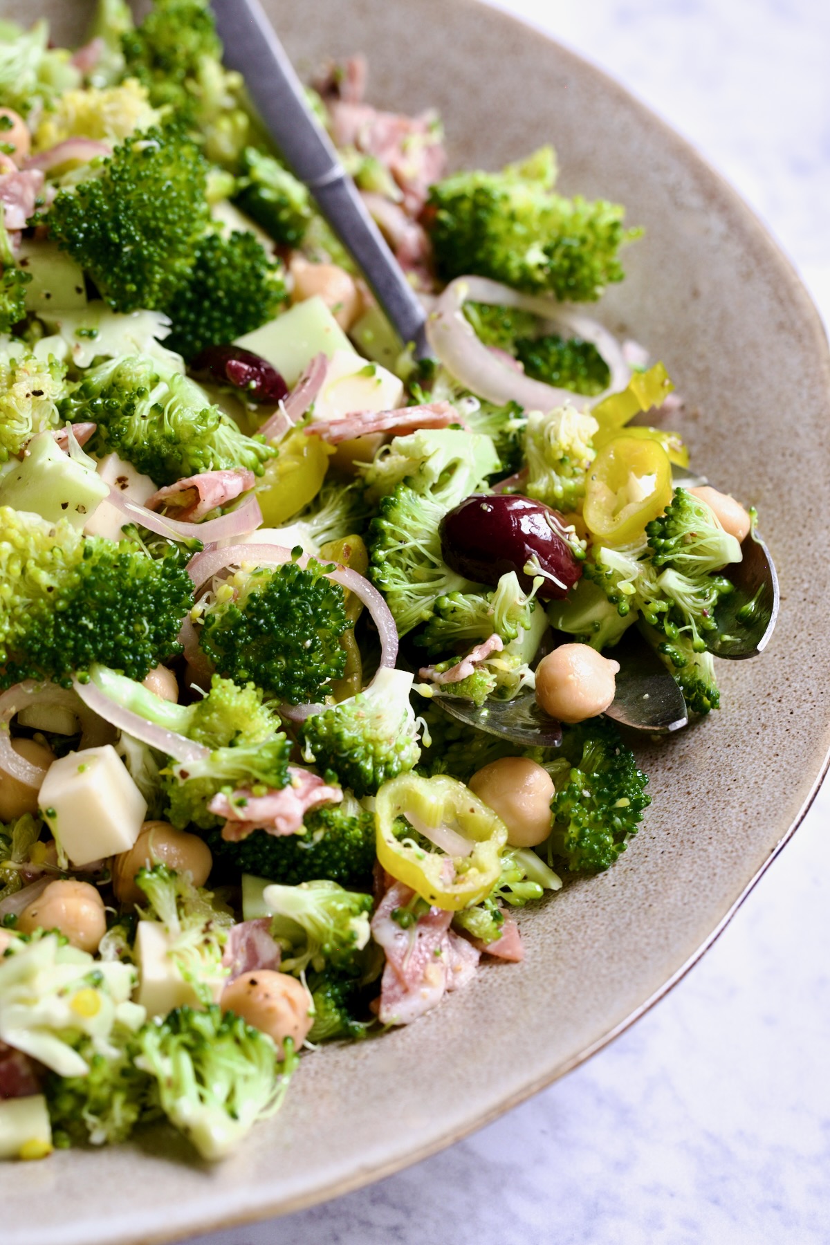 Italian Broccoli Salad in earthenware bowl with serving fork.