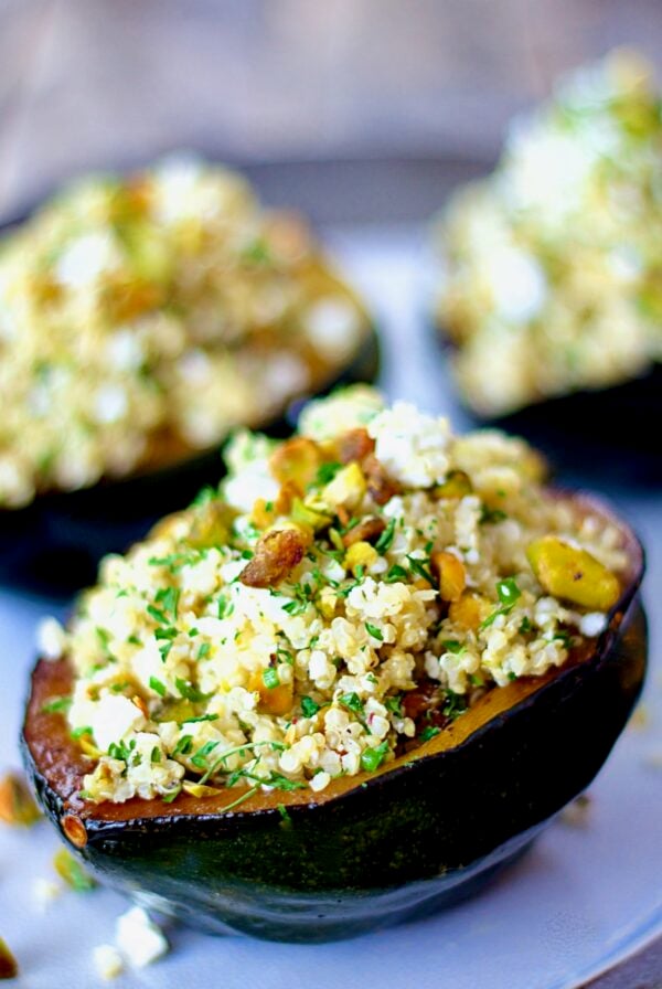 Quinoa Feta and Pistachio Stuffed Acorn Squash on a platter.