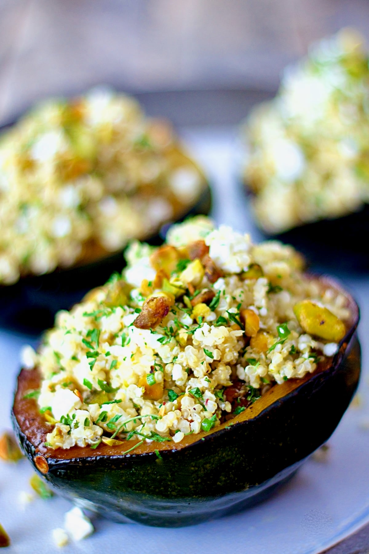 Quinoa Feta and Pistachio Stuffed Acorn Squash on a platter.