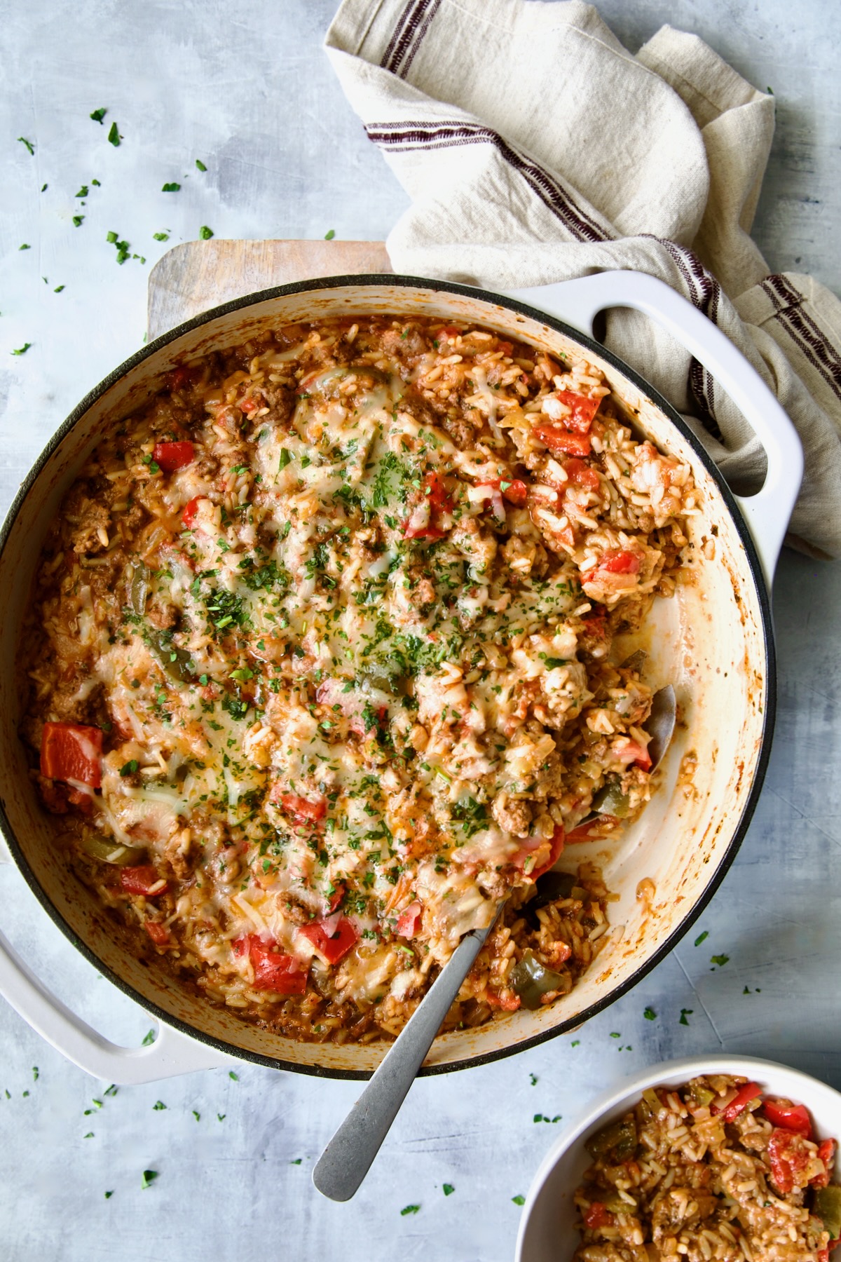 Unstuffed Peppers Skillet in white enamel cast iron skillet with some served up in white bowl.