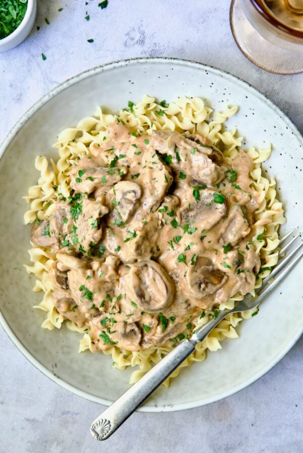 Date Night Beef Stroganoff over curly egg noodles in dinner bowl.