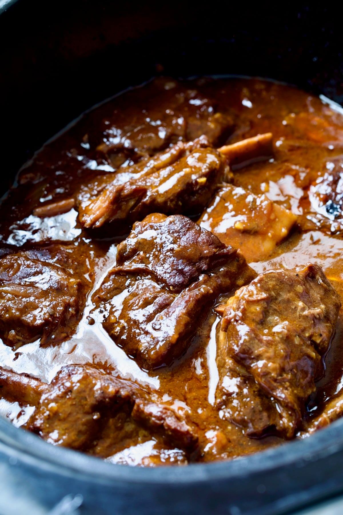 Close-up of beef ribs in slow cooker after being thickened.