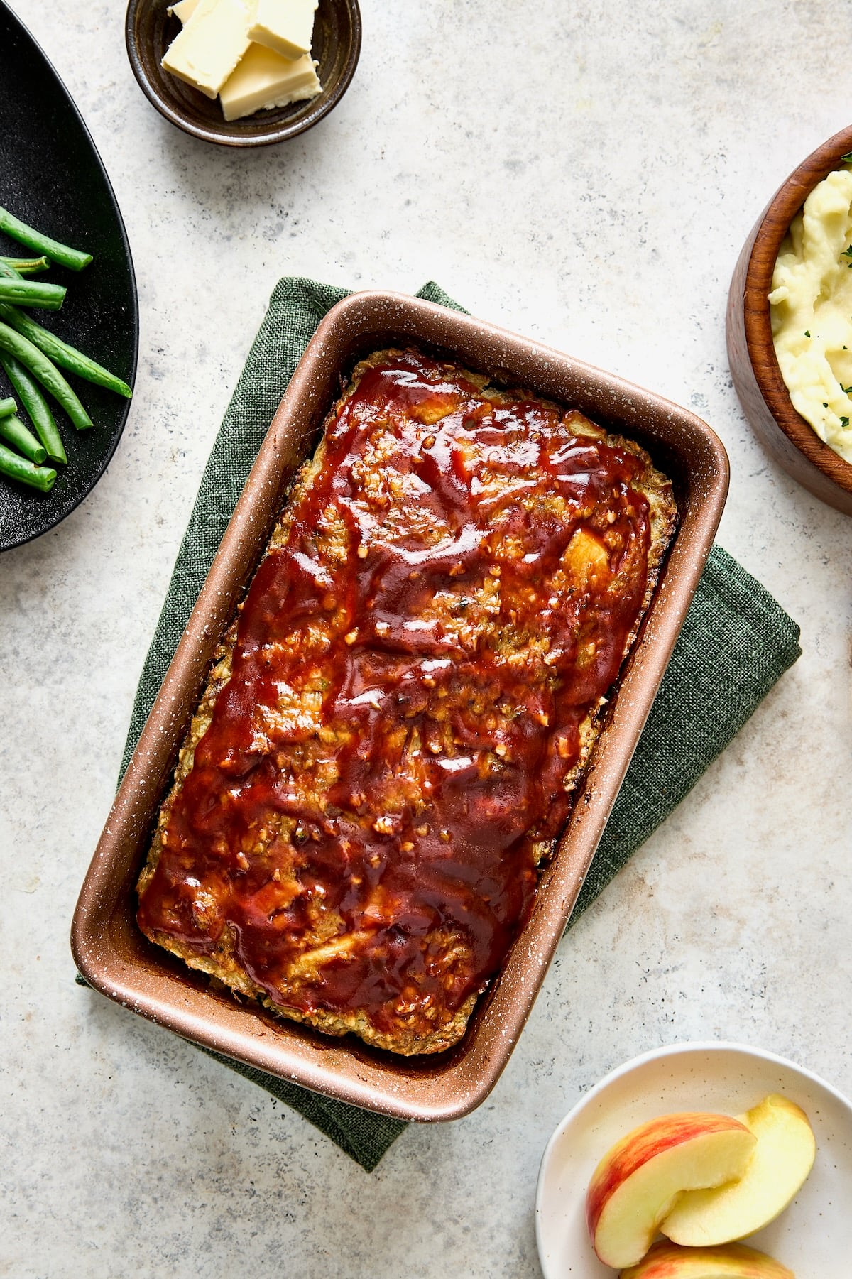 Glazed meatloaf in brown loaf pan.
