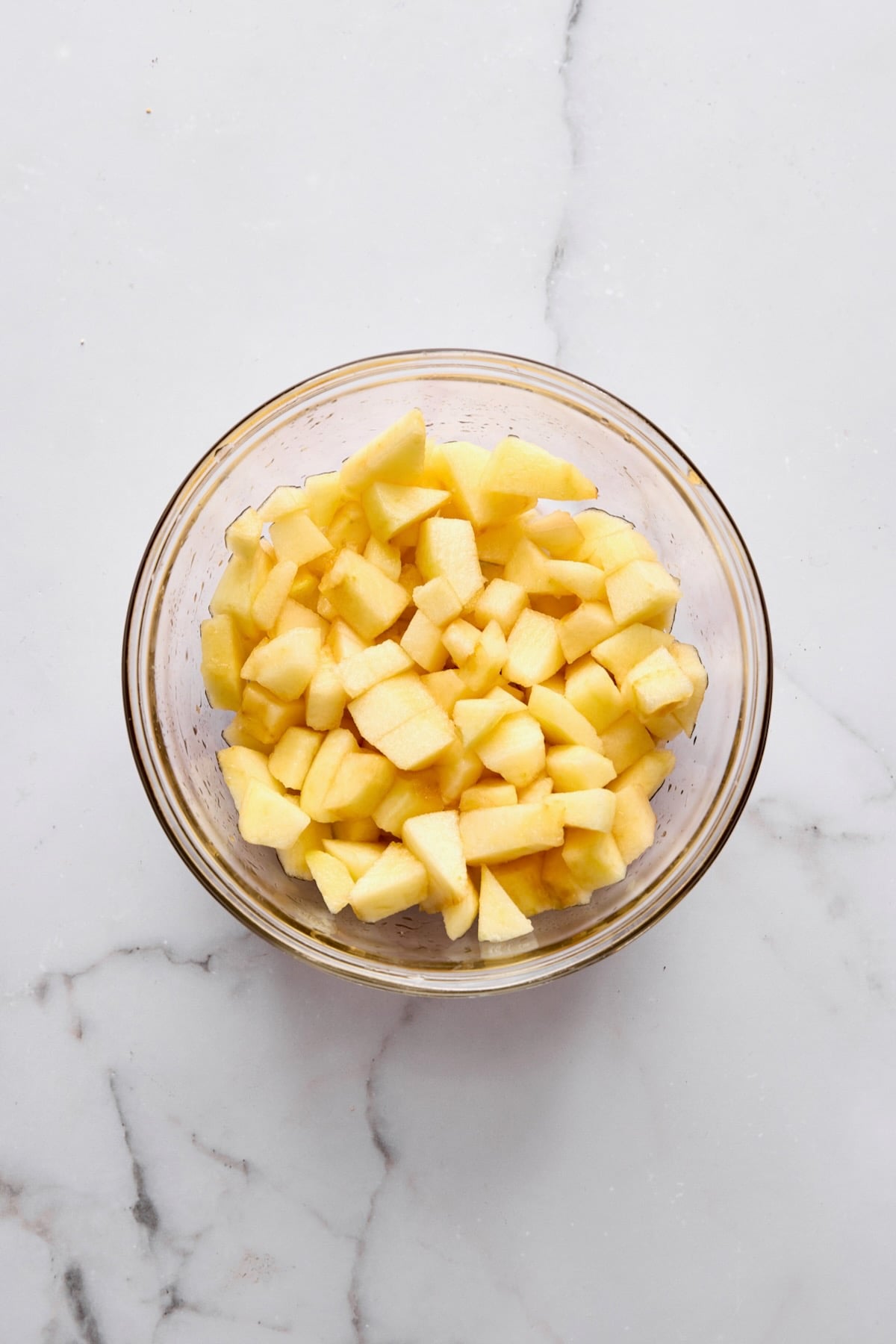 Chopped apples in glass bowl.