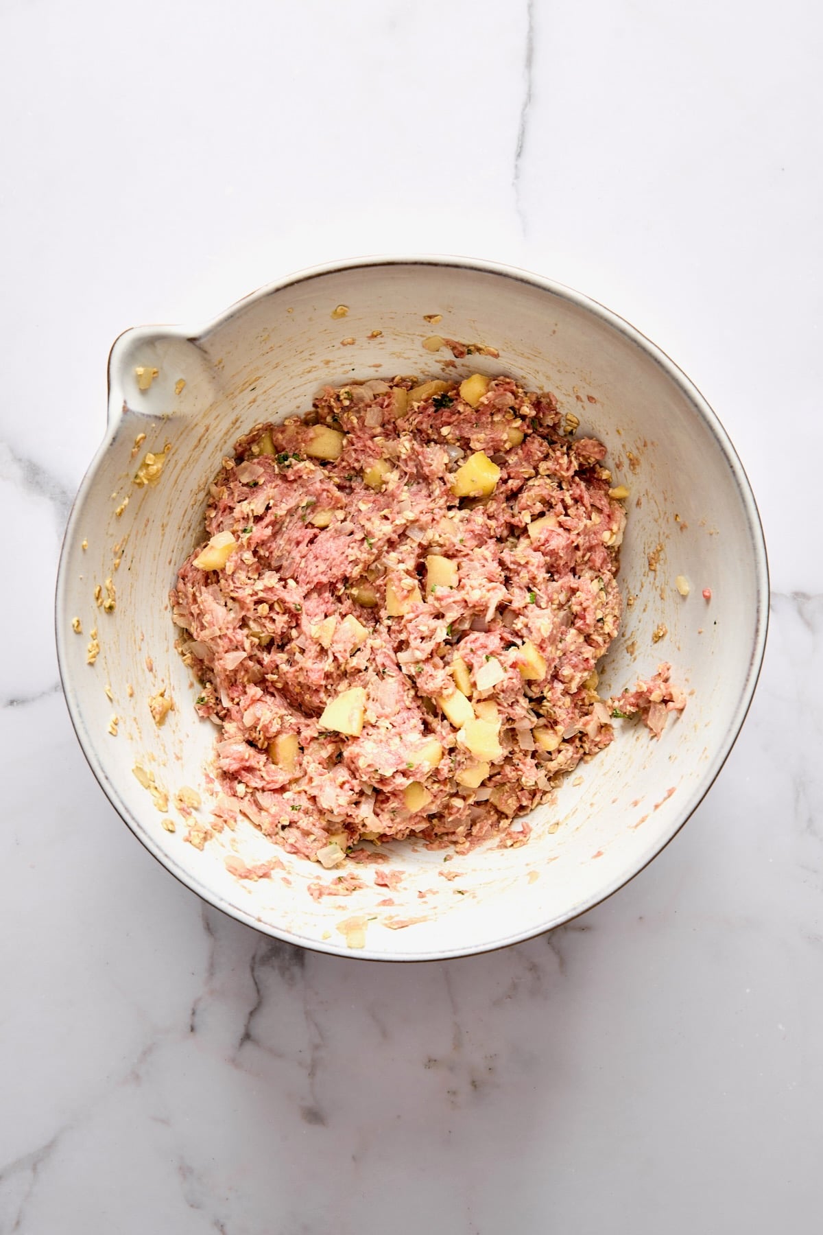 Fully combined turkey meatloaf mixture in white mixing bowl.
