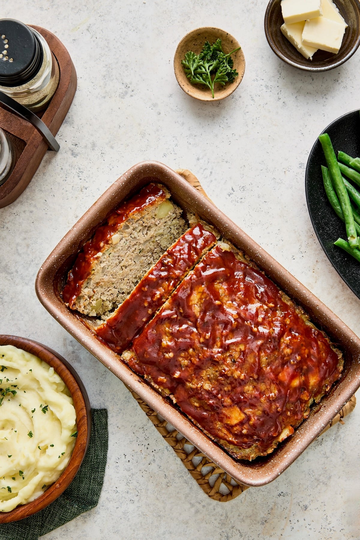 Turkey Apple Meatloaf with Balsamic Ketchup Glaze in loaf pan with two slices cut.