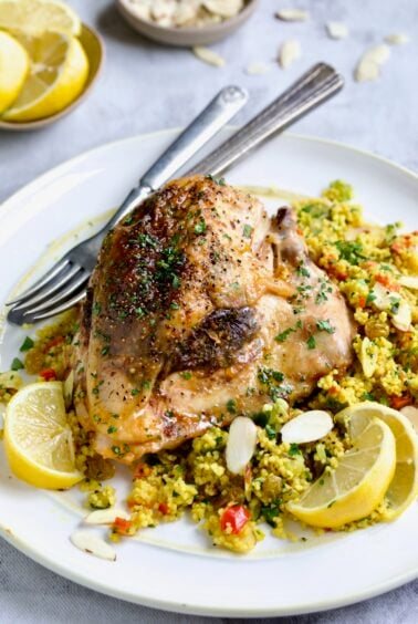 One serving of Moroccan Chicken with Jeweled Couscous on round white plate.