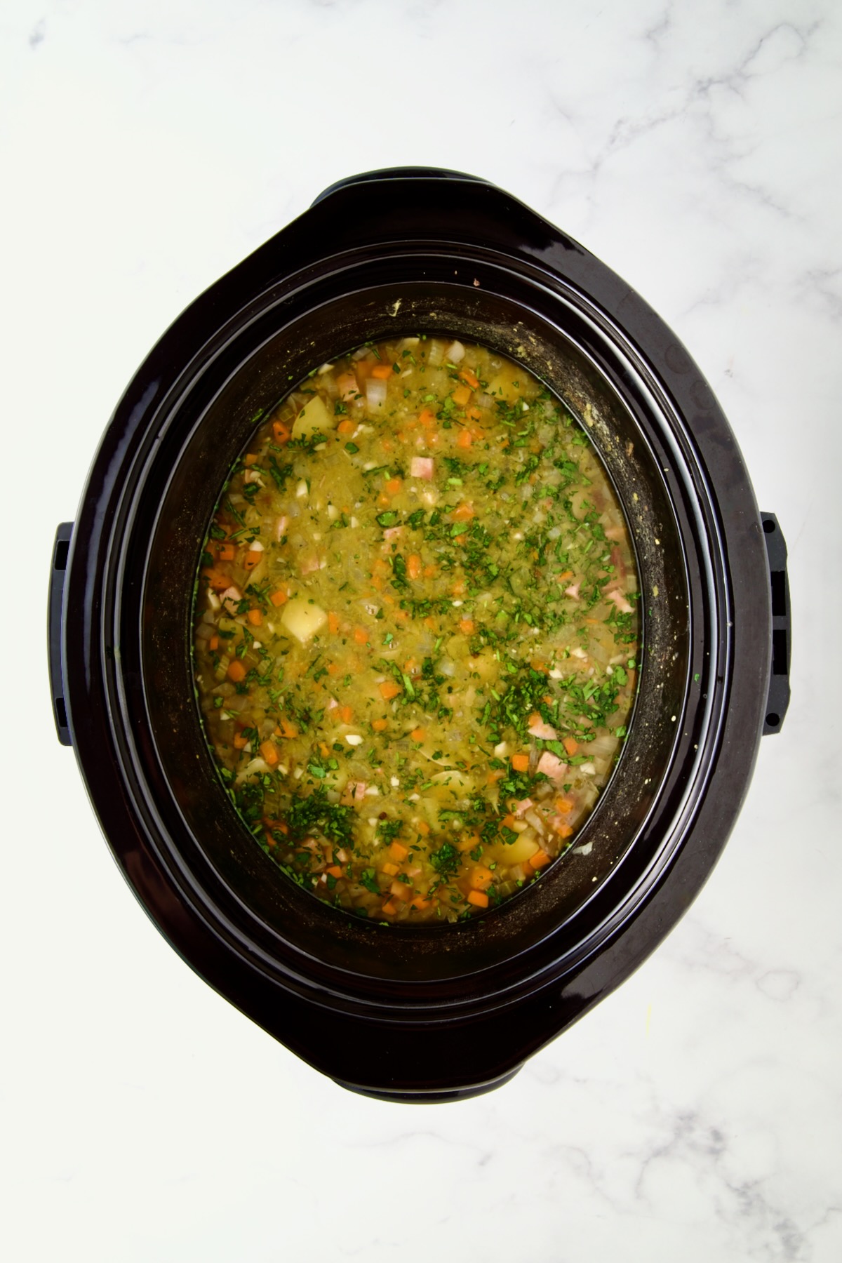 Slow Cooker Split Pea Soup in black slow cooker after being cooked.