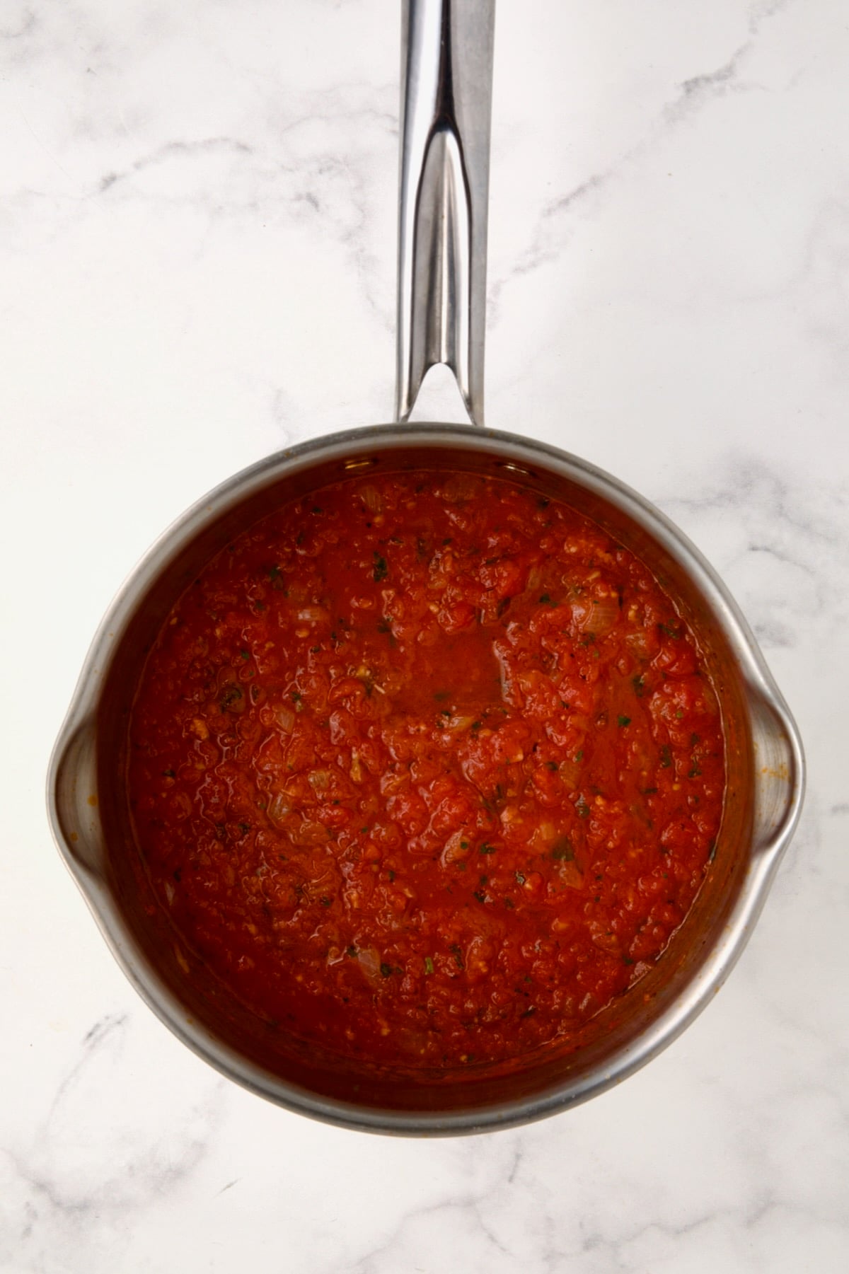 Cooked tomato sauce in stainless steel saucepan.