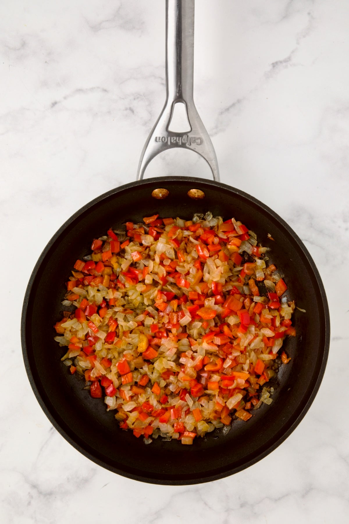 Cooked onions and red bell pepper in nonstick skillet.