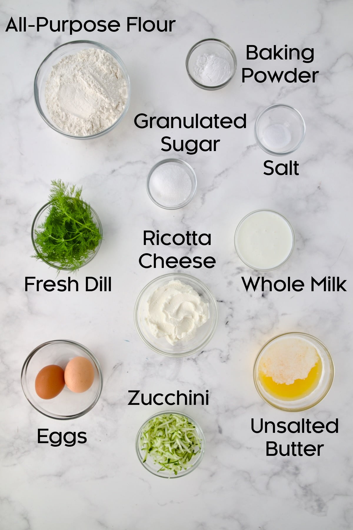 Ingredients for Dill Zucchini and Ricotta Muffins in glass bowls.