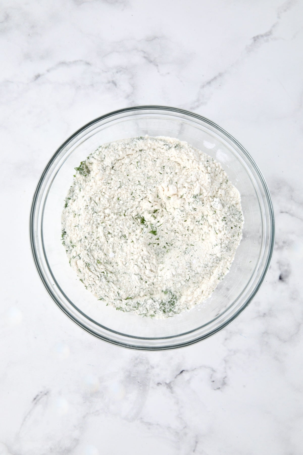 Dry ingredients for muffins in a glass bowl.
