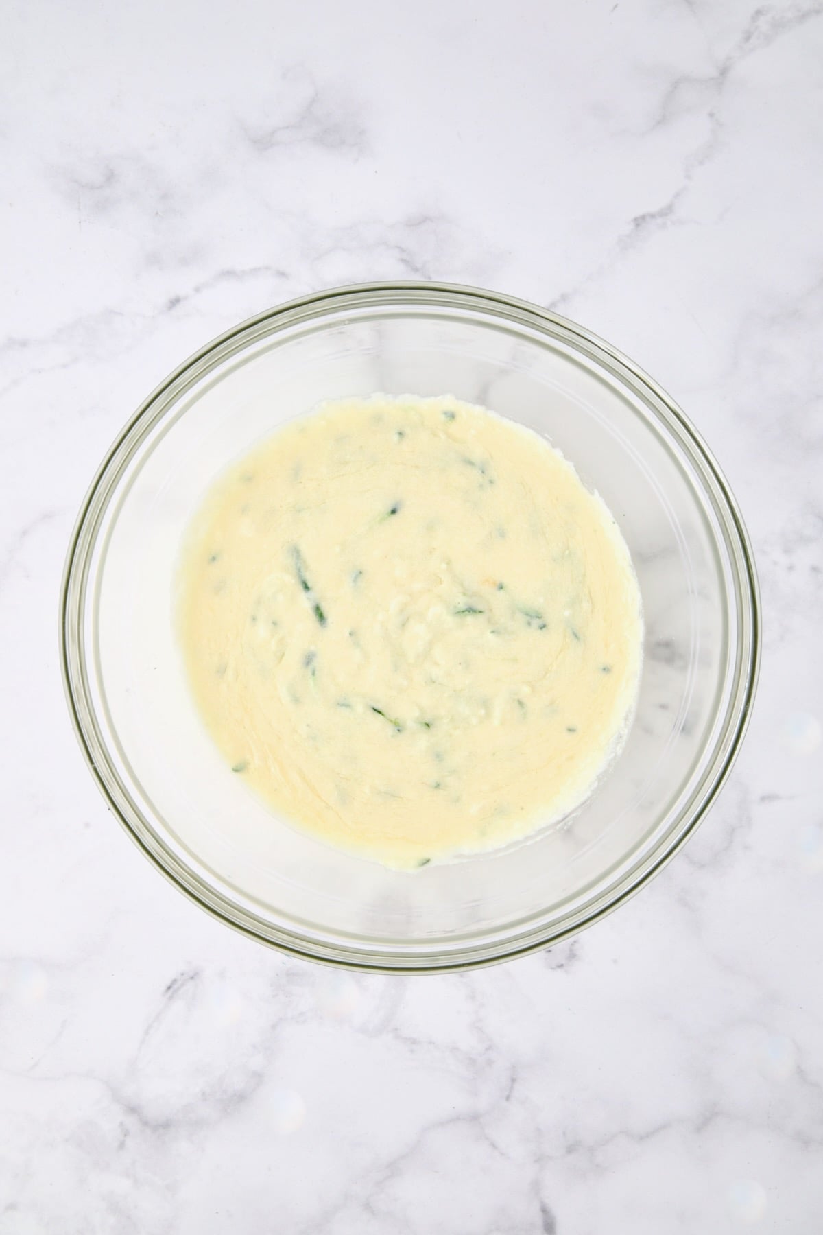 Wet ingredients for muffins in glass bowl.