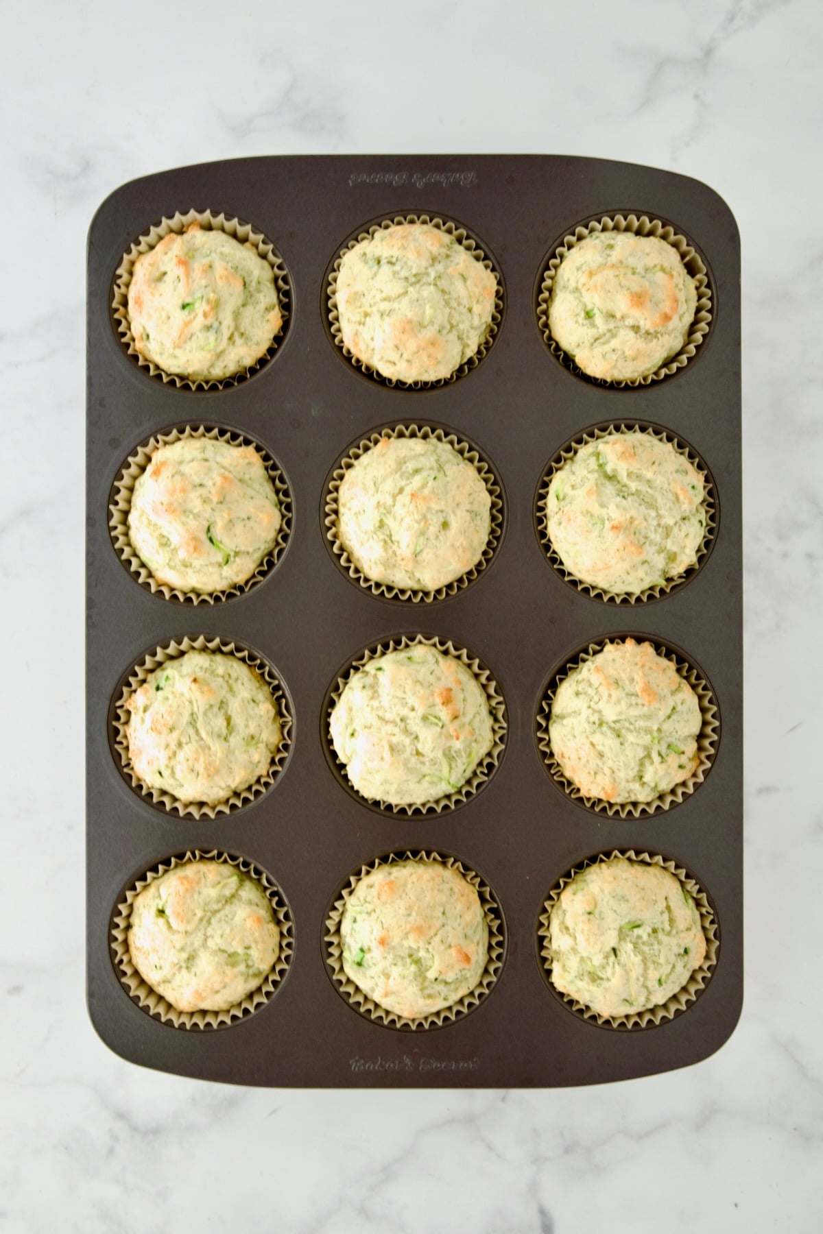 Baked Dill Zucchini and Ricotta Muffins in 12-cup muffin pan.
