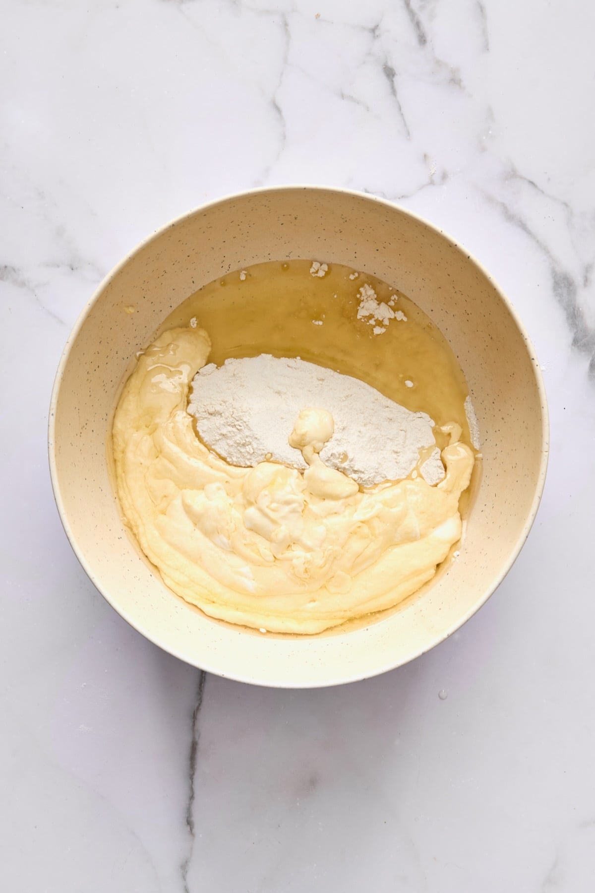 Wet and dry ingredients for coffee cake combined in bowl.