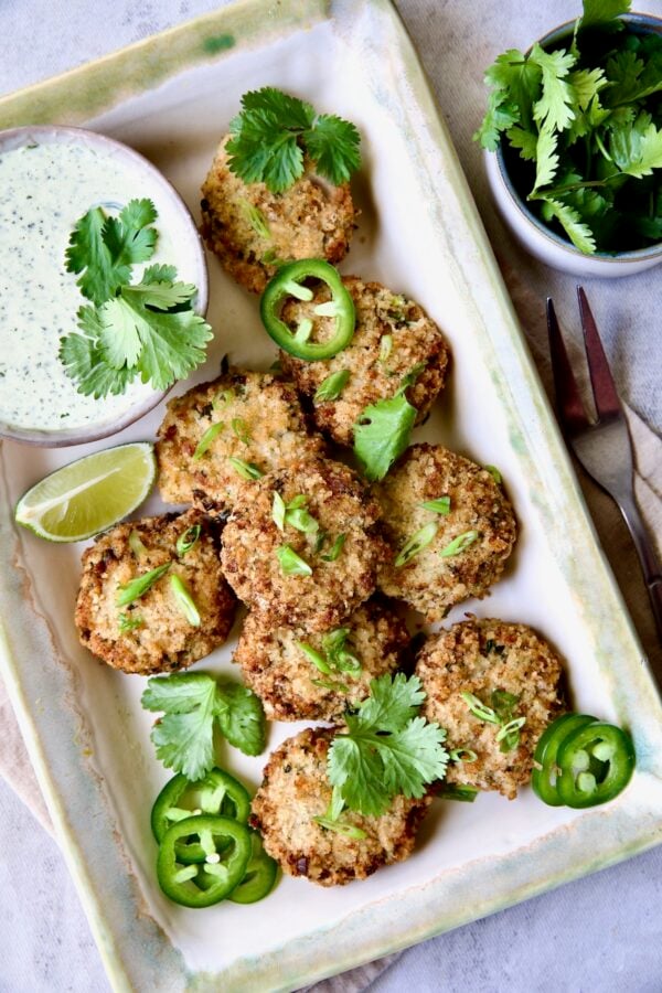 Thai Green Curry Shrimp Cakes on rectangular platter garnished with jalapeno slices and cilantro leaves.