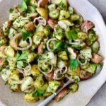 Herb and Vinegar Potato Salad in earthenware bowl with serving fork.