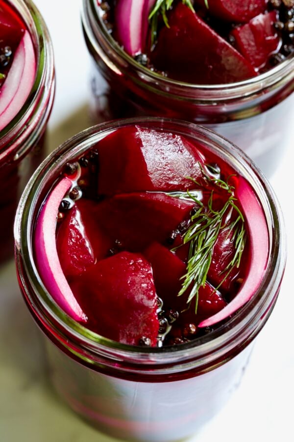 Fully filled pint jar with beets, dill, red onion and black peppercorns.