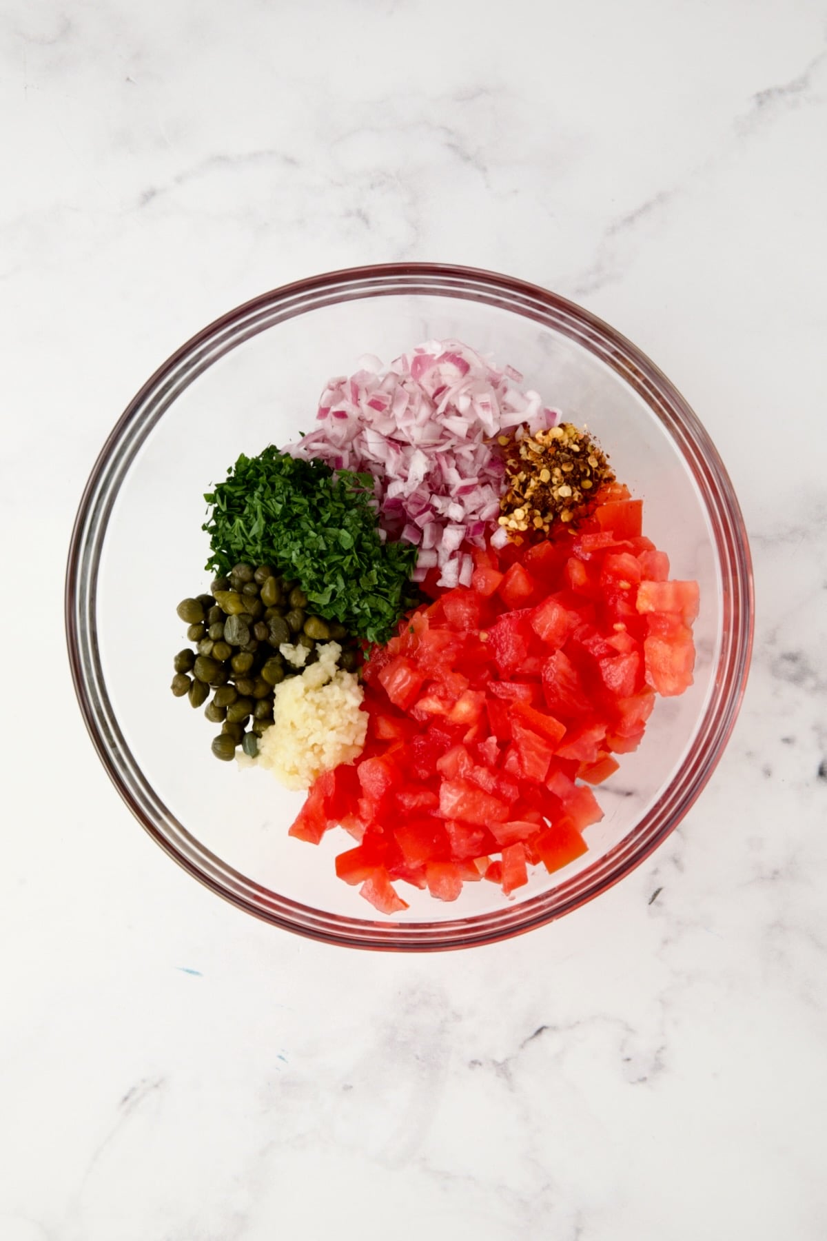 Ingredients for relish in glass bowl before being combined.
