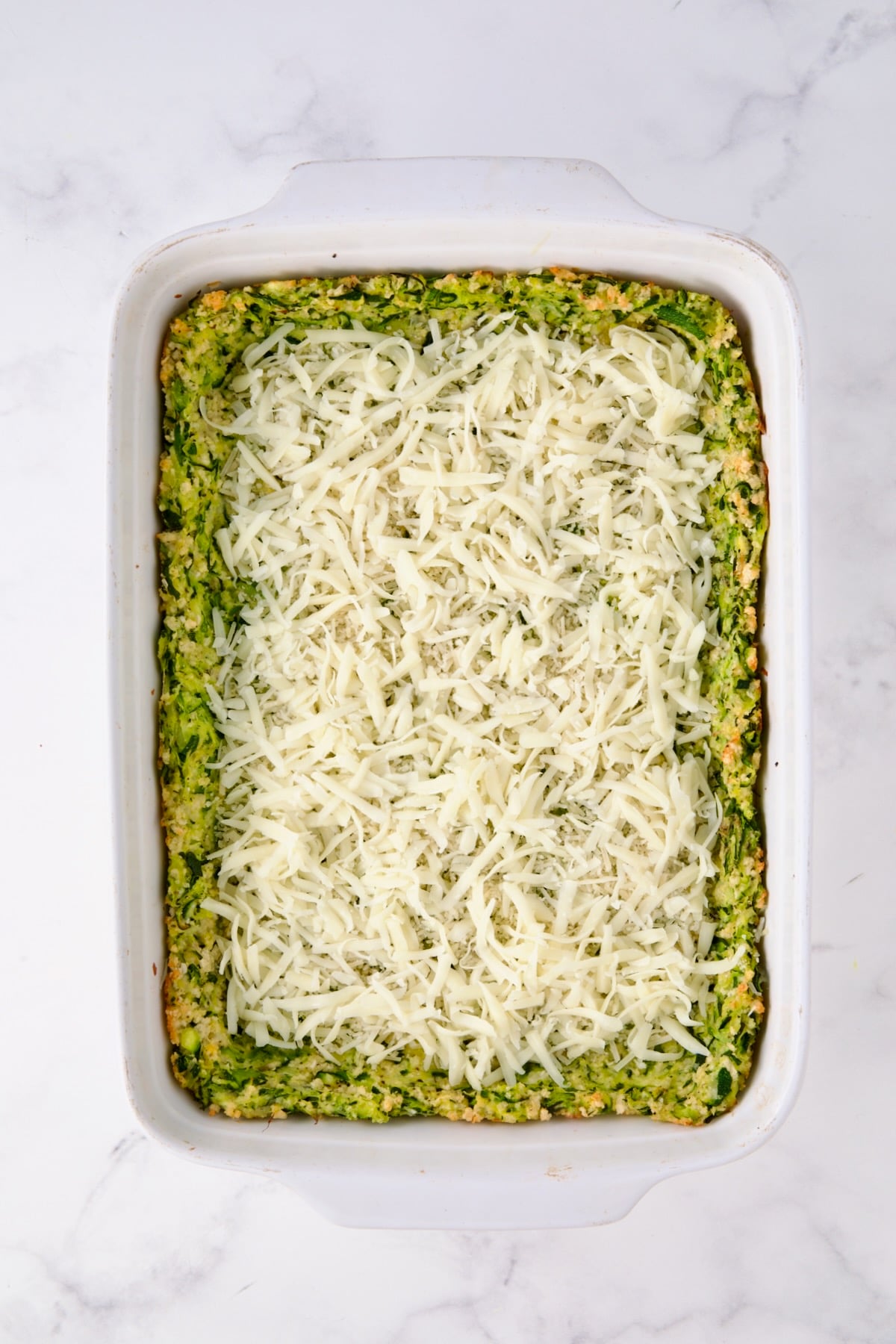 Layer of cheese over zucchini crust.