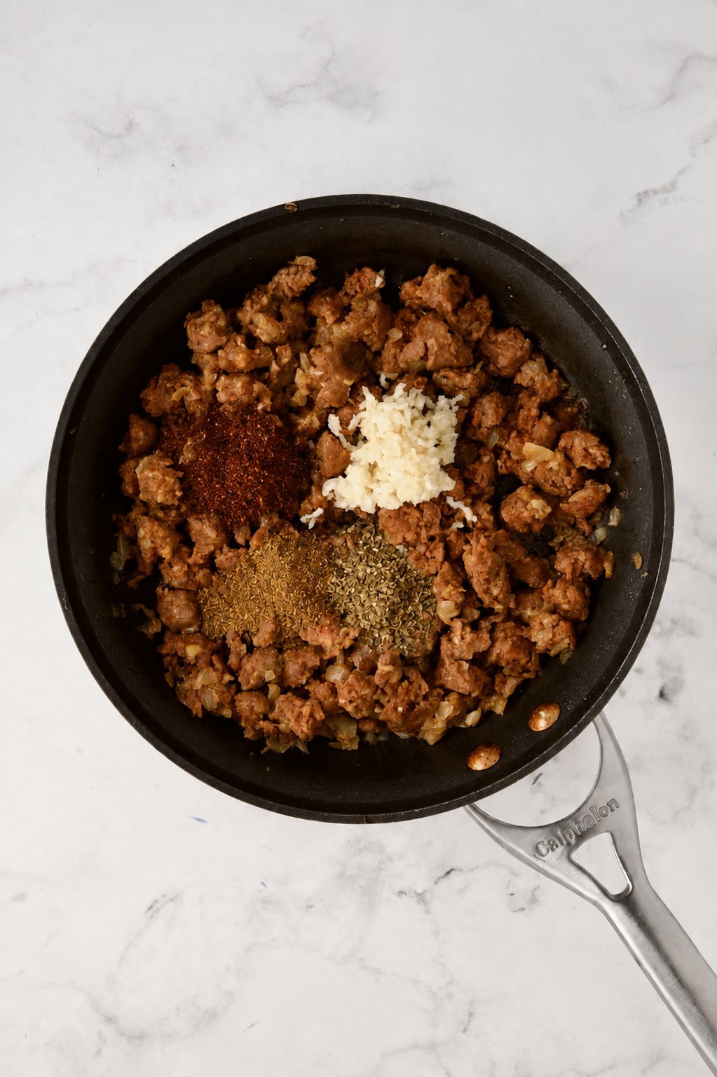 Ground chorizo, garlic, chili powder, cumin and dried oregano in nonstick skillet.
