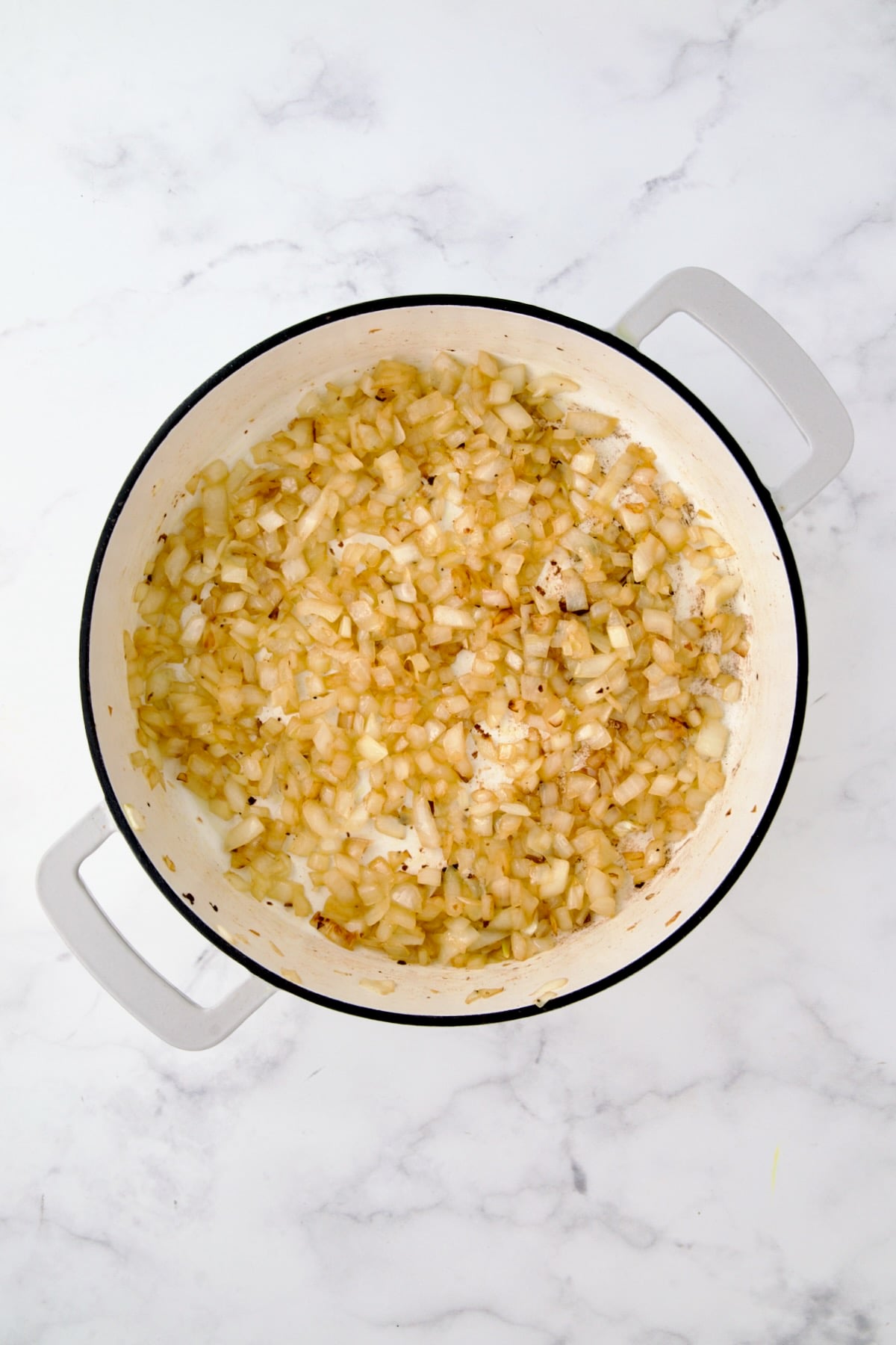 Sauteed onion in white enamel cast iron skillet.