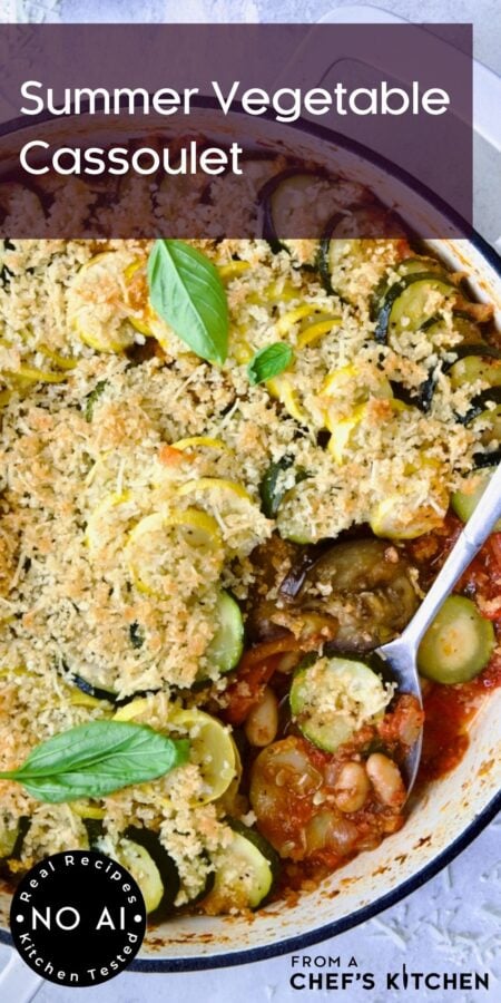 Pinterest graphic for Vegetarian Cassoulet showing it in a white enamel cast iron skillet with serving spoon.