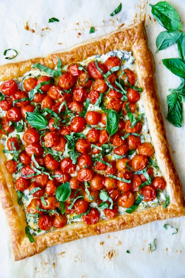 Cherry Tomato Puff Pastry Tart garnished with fresh basil leaves.