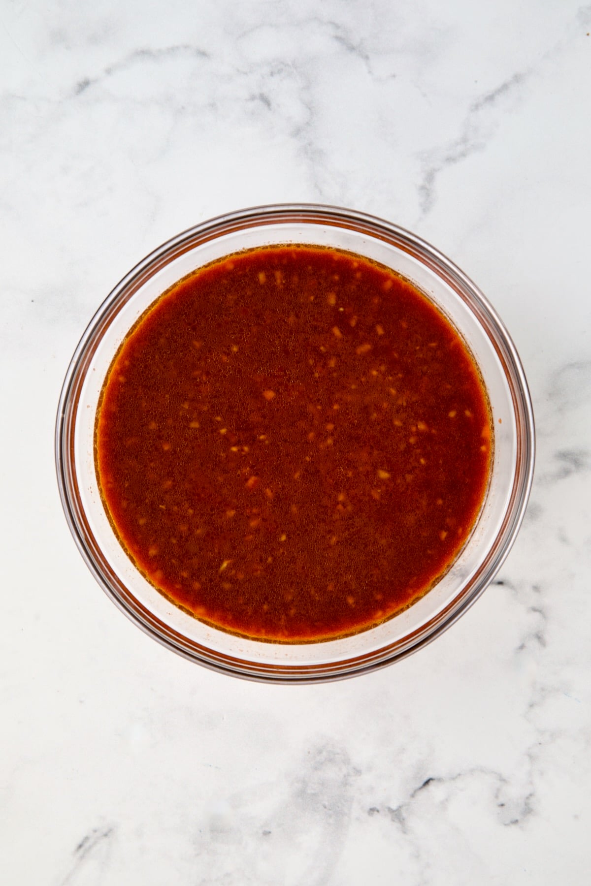 Sauce for chicken thighs in glass bowl.