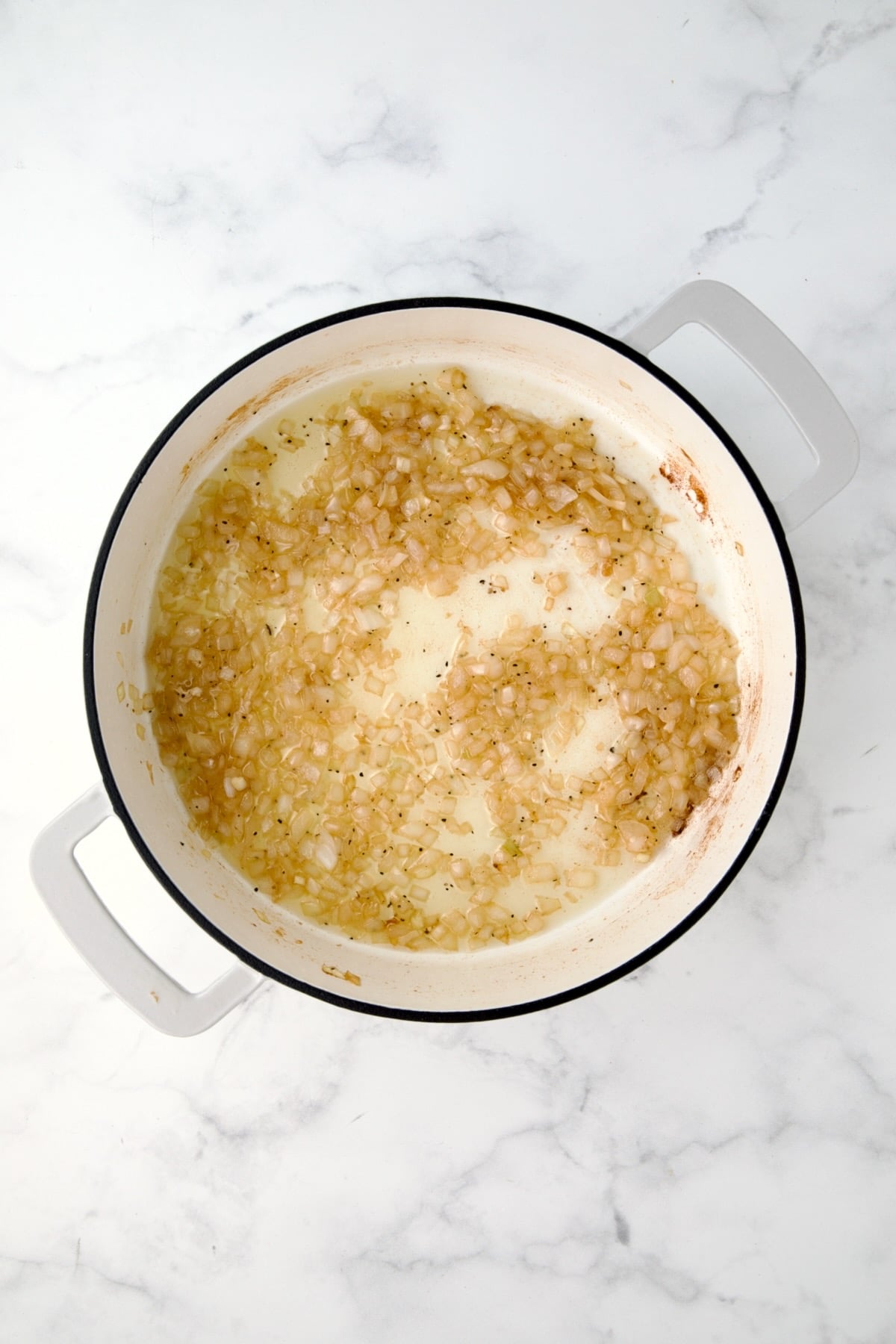Cooked onions in white enamel cast iron skillet.