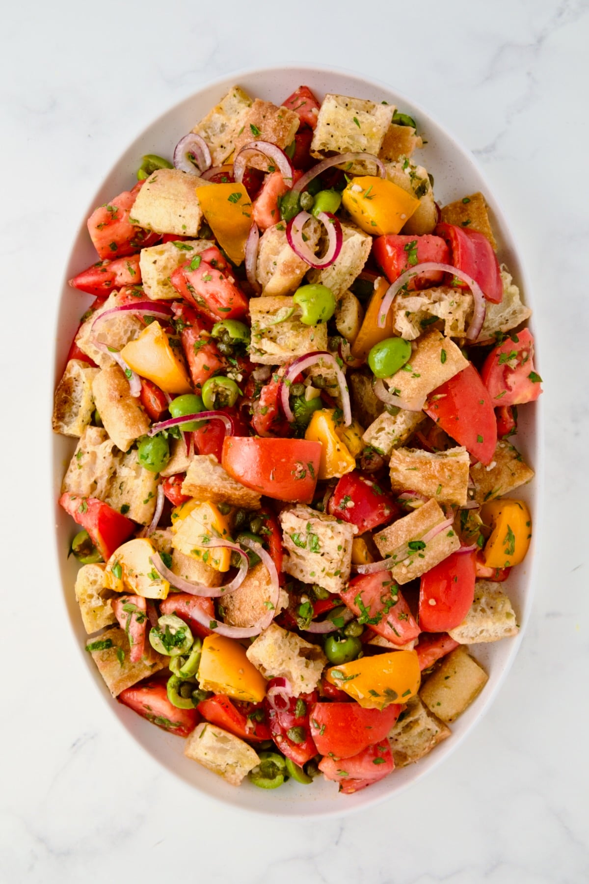 Panzanella on oval white platter before cheese is added.