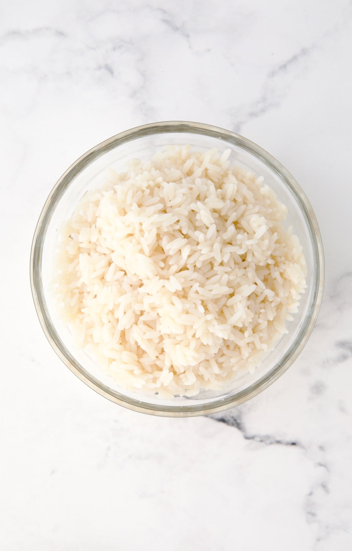 Cooked white rice in glass bowl.