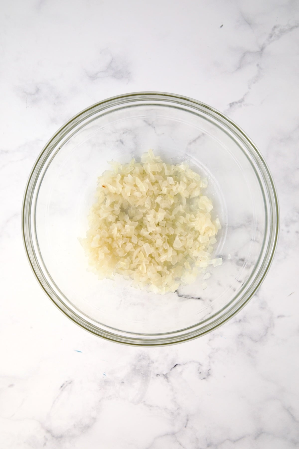 Cooked onions in glass bowl.