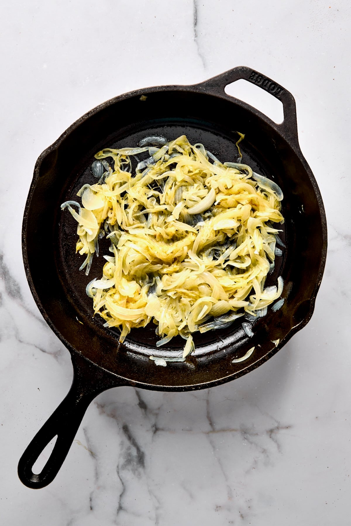 Cooked sliced onion in cast iron skillet.