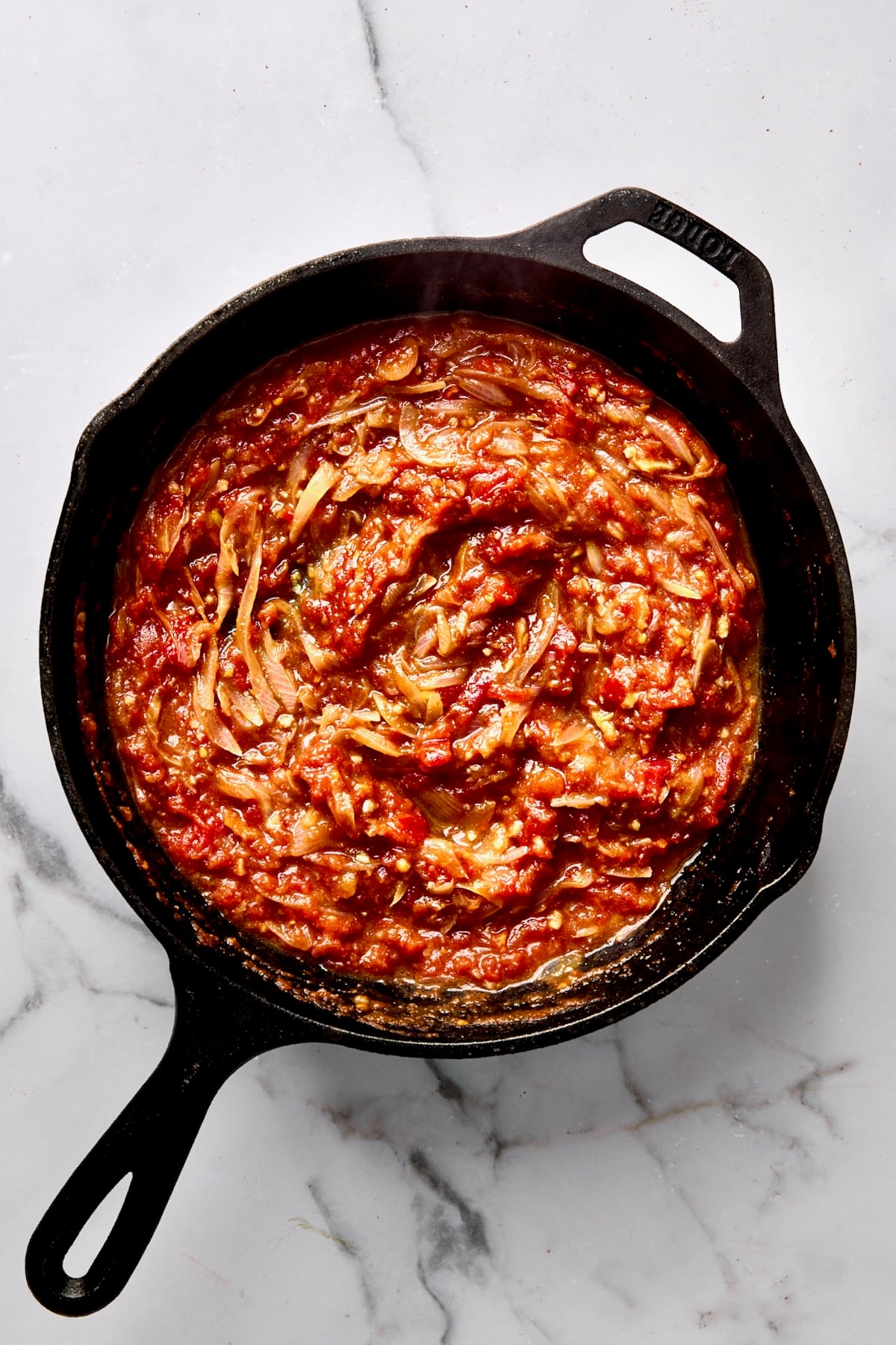 Cooked tomato sauce in cast iron skillet.