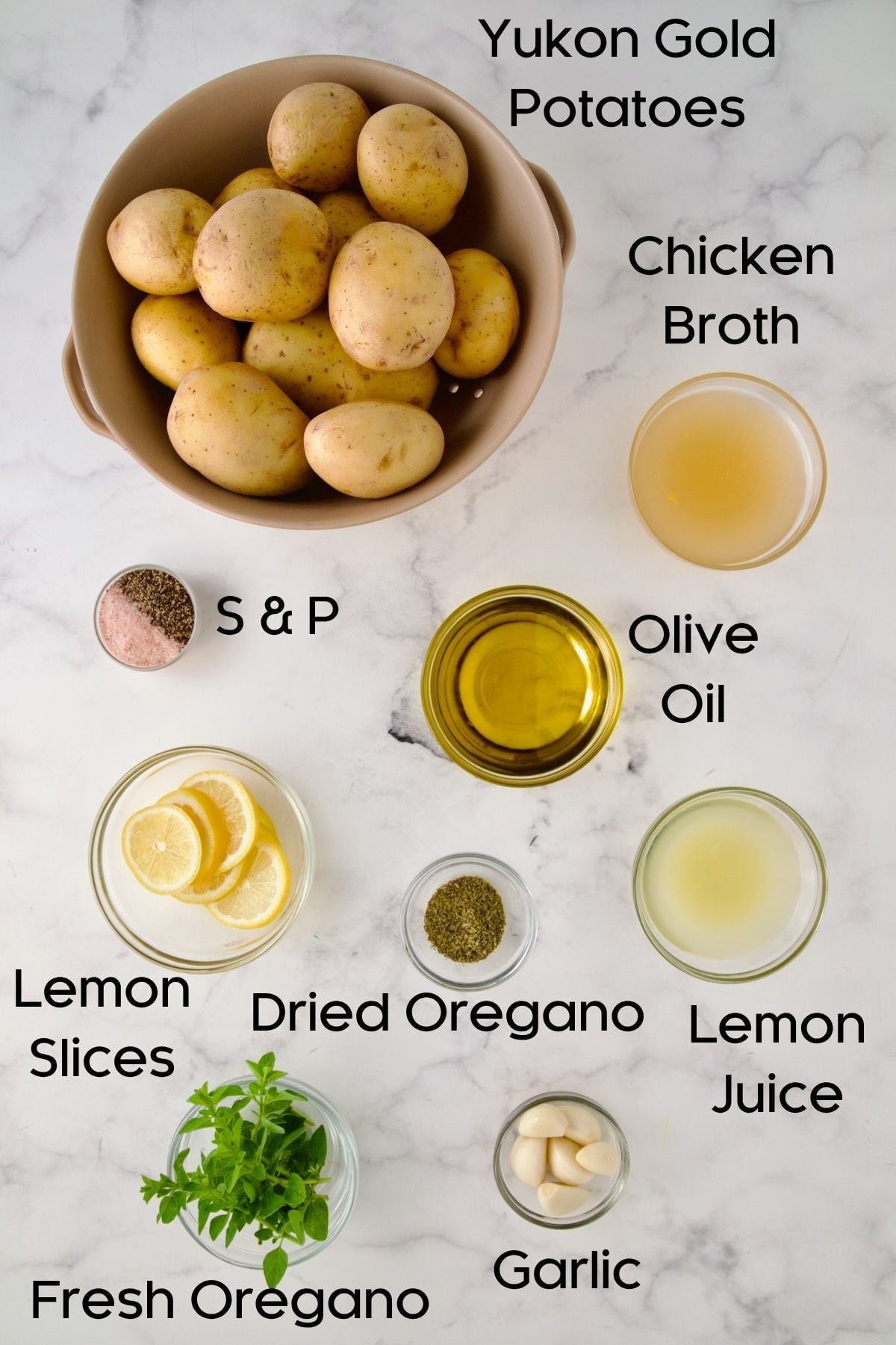 Ingredients for Greek Roasted Potatoes in glass bowls.